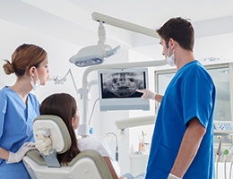 implant dentist in Ann Arbor showing a patient their X-rays 