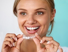 Woman holding Invisalign tray