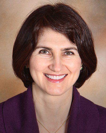 Smiling Ann Arbor dental patient wearing purple sweater