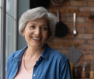 older woman smiling after getting dentures in Ann Arbor