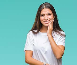 Woman with a toothache in Ann Arbor holding her cheek