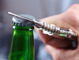 Person using bottle opener to open a beverage