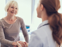 Woman and dentist discussing how to make dental implants affordable in Ann Arbor