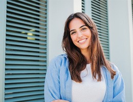 Woman with white teeth smiling while standing outside