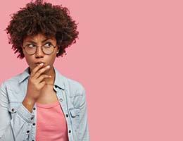 Woman with pink background wondering about Invisalign