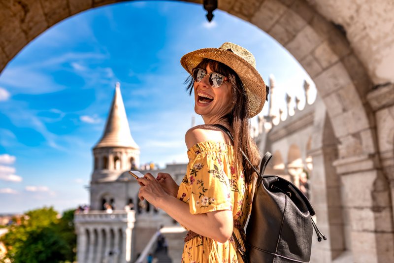 woman smiling and traveling with Invisalign