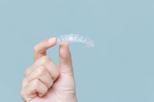 Invisalign aligner against a light blue background.