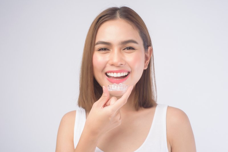 Young woman holding her Invisalign tray