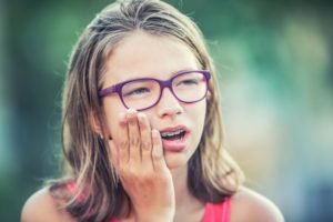 a teen holding their jaw in pain